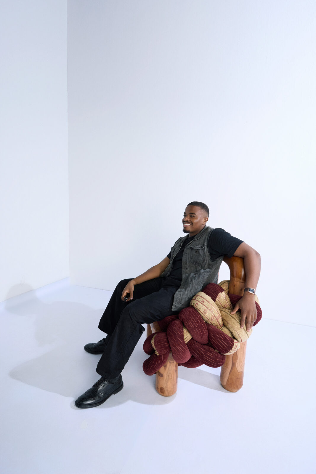 A man seated in the Apo Chair, smiling