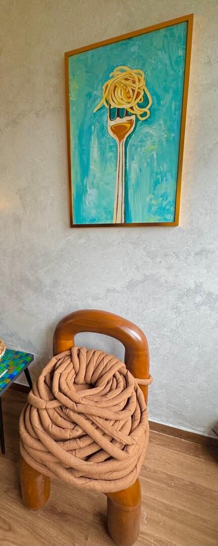 The Apo Chair styled in a room, beneath a painting