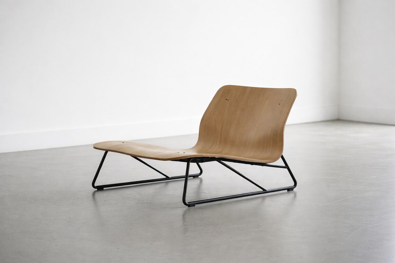 Igbako Chair, a low plywood lounge chair on a slender steel frame